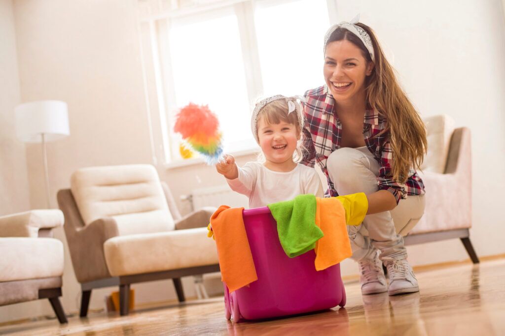 Daughter and mother cleaning home together and having fun.